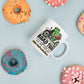 White 11 oz Road Toad Coffee mug with roadtoadcoffee.com next to donuts