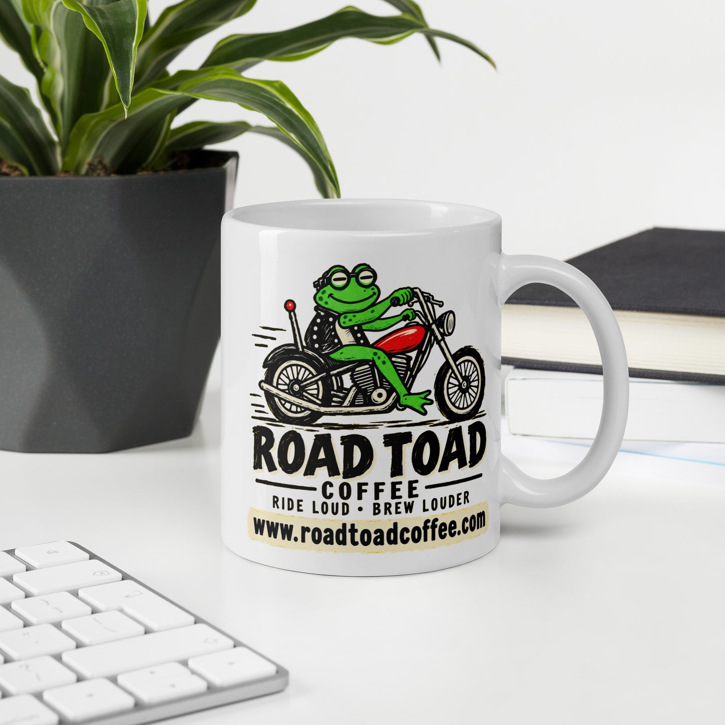 White 11 oz Road Toad Coffee mug with roadtoadcoffee.com on an office desk