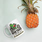 White 11 oz Road Toad Coffee mug with roadtoadcoffee.com next to a pineapple